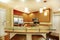 Ivory kitchen room interior with brown cabinets and stainless steel appliances.