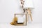 IWooden frame with place for text. Cotton branches, skandi lamp and sweater.