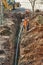 Izhevsk, Russia - May 08 2021: Team of workers stands by narrow trench with new water pipe