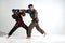 Jab of professional fighter, fighting guys in kimono and boxing gloves during mixed fight sparring, martial arts concept