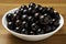 Jabuticaba in the bowl on wooden table. Jaboticaba or Jabuticaba is the native Brazilian grape tree. Species Plinia Cauliflora. Br