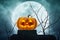Jack O Lantern pumpkin on the rock over dead tree and moon