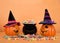 Jack o lanterns wearing witch hats with cauldron of candy