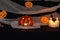 Jack pumpkin head on a dark background with gauze and decorations in the form of paper-cut bats and pumpkins. Burning candles.