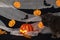 Jack pumpkin head on a dark background with gauze and decorations in the form of paper-cut bats and pumpkins. Burning candles.