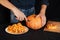 Jack`s Halloween pumpkin. Hands of a man with a knife cutting orange pumpkin