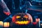 Jack`s Halloween pumpkin lantern, burning candles, hands with a knife piercing his head