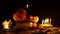 Jack`s two carved pumpkins stand on old books against a black background in light of many candles