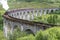 Jacobite locomotive train,blowing steam,crossing Glenfinnan Viaduct,amongst Scottish Highland scenery,Glenfinnan,Inverness-shire,