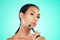 Jade roller, beauty and woman with face massage in studio for wellness, grooming or skincare on blue background. Facial