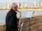 Jaffa, Israel - February 4, 2017: An elderly street musician playing the trumpet against the background of skyscrapers of Tel Aviv