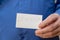 In jagged handwriting, the word GENOCIDE is written. Man holding a white paper rectangle with handwritten text. Close-up of a