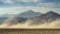 A jagged mountain range looms in the distance shrouded in a thick layer of swirling dust and sand.