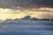Jagged snowy Triglav peak rises over sea of clouds at sunset