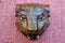 Jaguar head carved in wood decoration on a pink wall