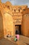 JAISALMER, RAJASTHAN, INDIA - DECEMBER 21, 2017: The entry Gate Suraj Pol to Jaisalmer Fort with a musician and a street seller in