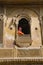 JAISALMER, RAJASTHAN, INDIA, November 2018, Tourist in traditional Rajasthani turban inside carved window of Kothari`s Patwon ki