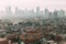 Jakarta Cityscape with high rise, skyscrapers and red tile hip roof local buildings with fog in the morning