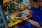 JAKARTA, INDONESIA - 3 MARCH, 2017: Local handcraft worker sitting by workplace desk using his tools creating