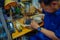 JAKARTA, INDONESIA - 3 MARCH, 2017: Local handcraft worker sitting by workplace desk using his tools creating