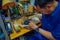 JAKARTA, INDONESIA - 3 MARCH, 2017: Local handcraft worker sitting by workplace desk using his tools creating