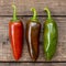 Jalapeno peppers in various stages of ripening on wooden board. Square format