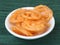 Jalebi, traditional indian sweet dessert,served over a white plate on a rustic wooden background, selective focus