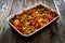 Jambalaya one pot dish - fried chicken breasts with white rice, tomatoes, bell pepper and celery on wooden table