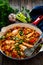 Jambalaya one pot dish - fried chicken breasts with white rice, tomatoes, bell pepper and celery on wooden table