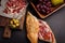 Jamon Iberico with white bread, olives on toothpicks and fruit on a dark background. Top view