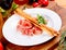 Jamon Serrano, Prosciutto Crudo or Parma ham and breadsticks on white plate