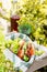 Jamon and vegetable sandwiches in a basket, grapes and berry juice, outdoor picnic