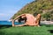 Jana shirshasana on a rock early morning near the sea