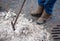 Janitor cleans the ice on the street with a crowbar