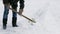 Janitor cleans snow of shovel.