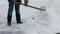 Janitor cleans snow of shovel.