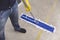 A janitor cleans the surface of the concrete floor of a factory with a flat mop