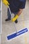 A janitor cleans the surface of the concrete floor of a factory with a flat mop