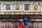 Janitor man cleaning wall of the temple that decorated with many forms and cultures of antique Buddha statues at Mahabodhi Temple.