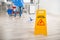 Janitor Mopping Floor By Wet Caution Sign In Office
