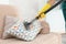 Janitor removing dirt from sofa cushion with steam cleaner