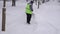 Janitor shovels snow in the city during a snowstorm, slow motion