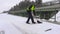 Janitor with snow shovel on bridge