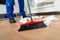 Janitor Sweeping Crumpled Papers On Floor