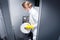 Janitor woman changing paper in public toilet