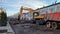 January 10, 2021 Taganrog, Russia. The excavator breaks the asphalt with a bucket and loads it into the truck