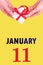 January 11th. Festive Vertical Calendar With Hands Holding White Gift Box With Red Ribbon And Calendar Date