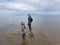 January 2021, Balikpapan Indonesia, lamaru beach, people enjoys calm ocean waves, muslim mother teach her daughter to swim