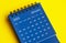 January 2025 blue desk calendar on yellow cover background.