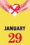 January 29th. Festive Vertical Calendar With Hands Holding White Gift Box With Red Ribbon And Calendar Date